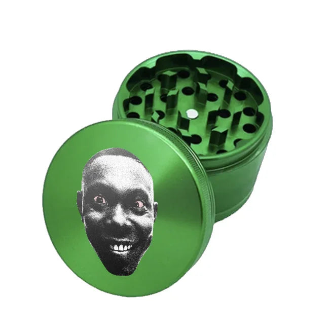 Green metal custom grinder with a face design on one side, on a white background