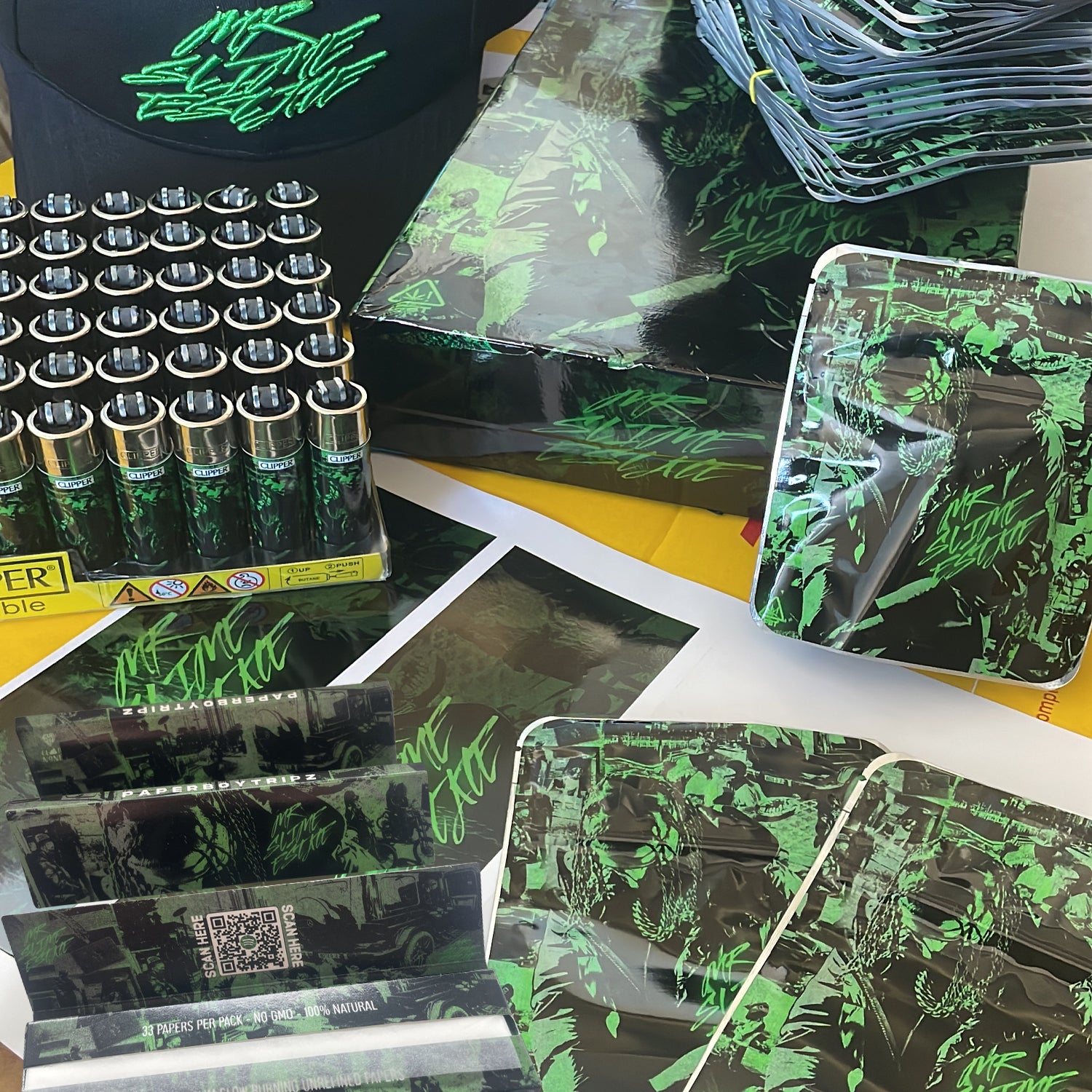 Collection of custom merchandise including boxes, packaging, and a hat with a brand logo. Paperboytripz album launch merch design & print by cloud n9ne.